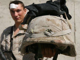 Американский солдат демонстрирует задержавший пулю кевларовый шлем