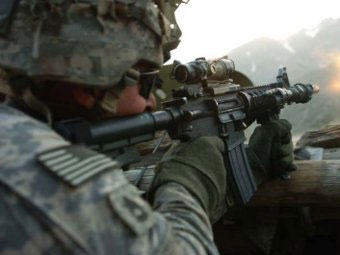 Американский солдат ведет огонь из автомата M4