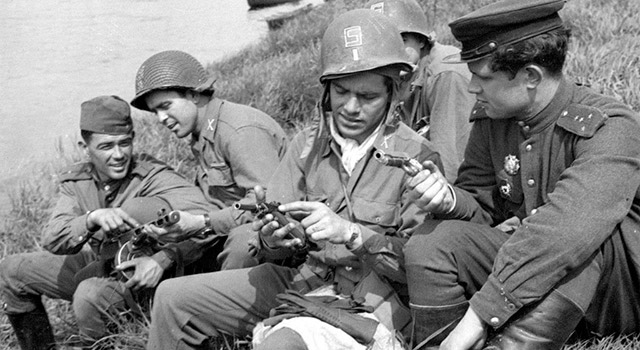 Военнослужащие РККА и армии США с пистолетами Colt M1911 и Luger и пистолетом-пулеметом ППШ-41. 1945 г